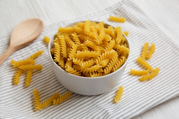 Uncooked Yellow Organic Rotini Pasta, side view.