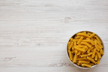 Uncooked Yellow Organic Rotini Pasta, top view. Flat lay, overhead, from above.