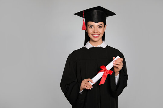 Happy student with graduation hat and diploma on grey background. Space for text - Powered by Adobe