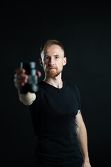 a man holding optics for a camera in a studio