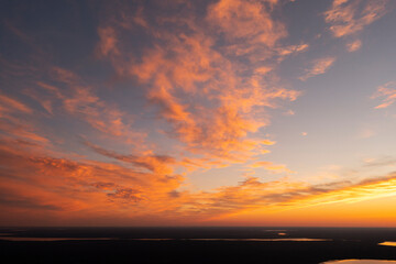 Fototapeta na wymiar Aerial view of a sunset sky background. Aerial Dramatic gold sunset sky with evening sky clouds over the lake. Stunning sky clouds in the sunset. Sky landscape. Aerial photography.