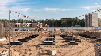 Monolithic reinforced concrete foundations for the construction of a residential building. Grillage at the construction site. Construction pit with foundations.