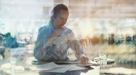 Attractive business woman working by her desk in office against sun light. Business concept 