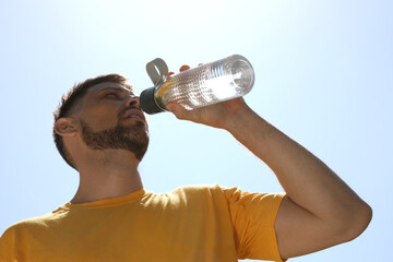 Man drinking water to prevent heat stroke outdoors