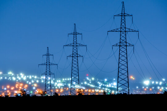 power lines in the evening on the background of blurred city lights