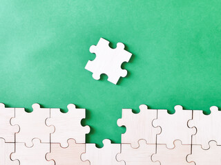 Selective focus top view jigsaw puzzle isolated on green background.