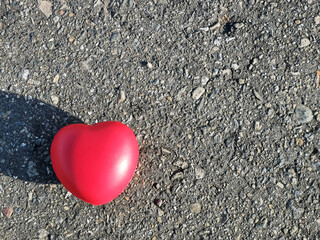 Obraz premium Red heart shape isolated on asphalt road with copy space.