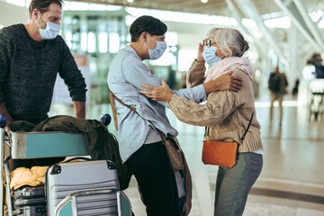 Senior woman receiving her family at airport after pandemic