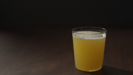 orange juice in glass on walnut wood table