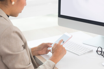 Close up of Woman hand Using a Smart Phone at office, Blank screen mobile phone for graphic display