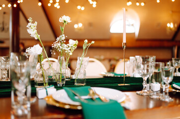 Beautiful flowers on table in wedding day. Beautiful table setting for a party, reception or other festive event emerald colour.
