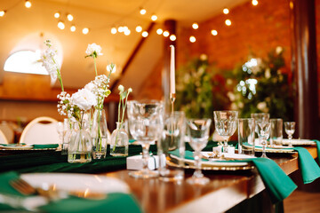 Beautiful flowers on table in wedding day. Beautiful table setting for a party, reception or other festive event emerald colour.