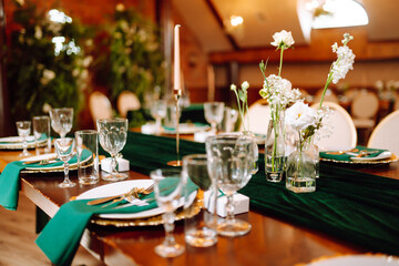 Beautiful flowers on table in wedding day. Beautiful table setting for a party, reception or other festive event emerald colour.