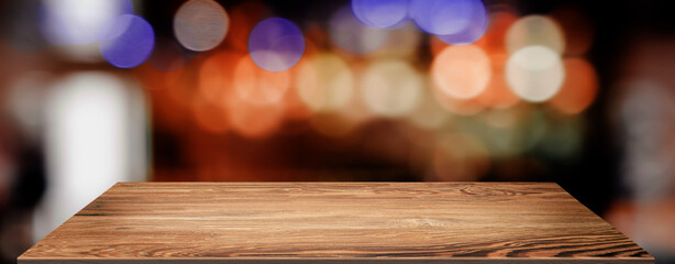 nightclub background.Empty brown wooden table with blur bar restaurant bokeh lights,banner mockup...