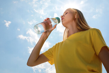 Woman drinking water to prevent heat stroke outdoors