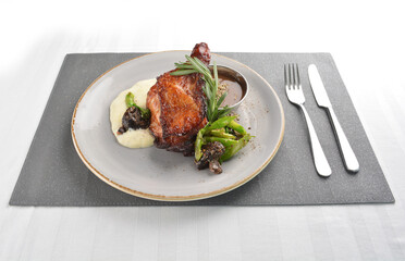 Texas grilled chicken leg confit with vegetables, mash potato and chef brown sauce in white background western main course menu
