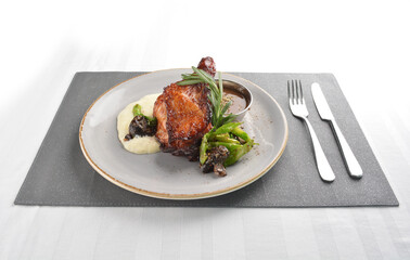 Texas grilled chicken leg confit with vegetables, mash potato and chef brown sauce in white background western main course menu