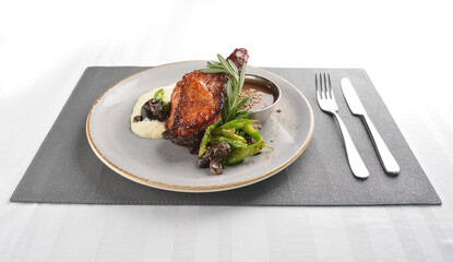 Texas grilled chicken leg confit with vegetables, mash potato and chef brown sauce in white background western main course menu
