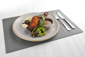 Texas grilled chicken leg confit with vegetables, mash potato and chef brown sauce in white background western main course menu