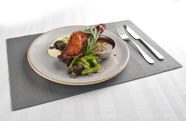 Texas grilled chicken leg confit with vegetables, mash potato and chef brown sauce in white background western main course menu