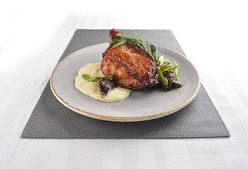 Texas grilled chicken leg confit with vegetables, mash potato and chef brown sauce in white background western main course menu