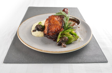 Texas grilled chicken leg confit with vegetables, mash potato and chef brown sauce in white background western main course menu