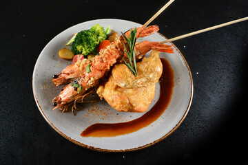 mixed grilled seafood skewer platter big tiger pawn with deep fried chicken and vegetables salad in black background western menu