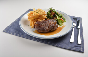 bbq grilled juicy wagyu beef tenderloin sirloin steak in brown black pepper sauce with French fries and vegetables salad dressing western cuisine menu