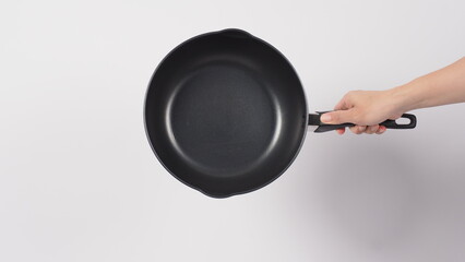 Pan cleaning. Man hand on white background cleaning the non stick pan with handy dish washing sponge which yellow color on the soft side and green on hard side for hygiene after cook. Electric pan. 
