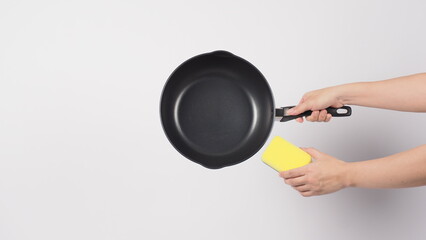 Pan cleaning. Man hand on white background cleaning the non stick pan with handy dish washing...