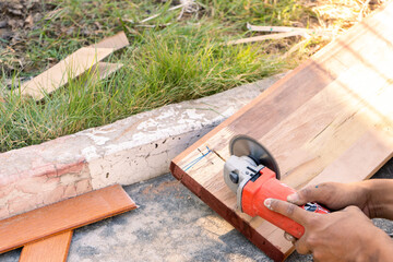 Carpenter working on woodworking machines in carpentry shop. Cut wood at outdoors with a lot of tools and accessories