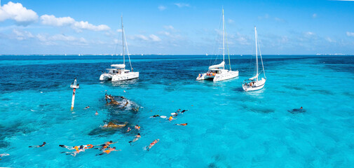 People snorkelling around the ship wreck near Cancun in the Caribbean sea. Beautiful turquoise...