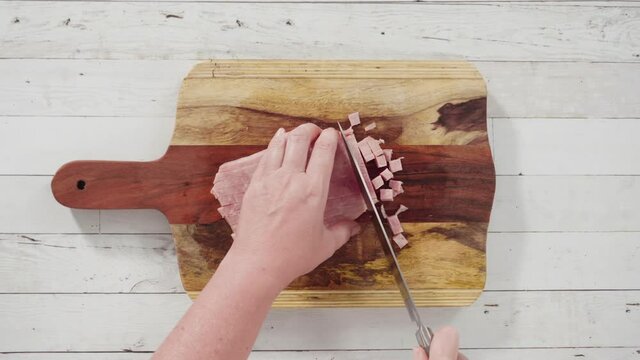 Flat lay. Cutting organic honey ham on a wood cutting board.