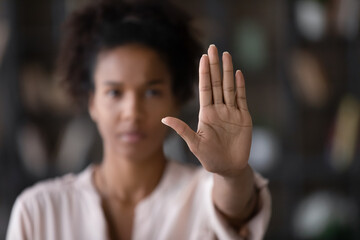 Close up of African American woman showing stop gesture with hand blurred background, young female protesting against domestic violence and abuse, bullying, saying no to gender discrimination - obrazy, fototapety, plakaty