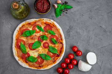 freshly baked Italian pizza with cheese and tomato sauce, garnished with basil leaves. Ingredients. view from above 