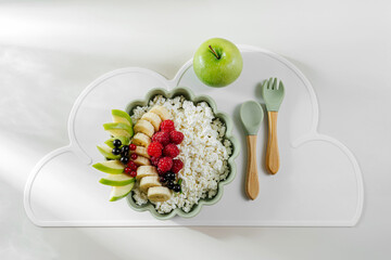 Children's Breakfast with cottage cheese, fruits and berrys. Cute table setting. Food idea for kids.