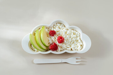 Children's Breakfast. Plate in the shape of a cloud with cottage cheese and  berry. Food idea for kids.