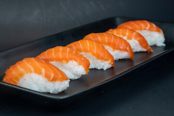 Salmon Nigiri on  black plate