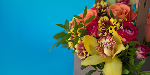 Bouquet with orchids on a blue square background. Banner.