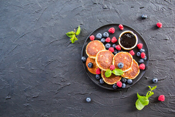 A healthy breakfast of cheese pancakes, berries, and honey. Creative atmospheric decoration