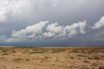 
Kyrgyzstan, the basin of the mountain lake Issyk-Kul combines sunny weather, thunderstorm front and clouds.