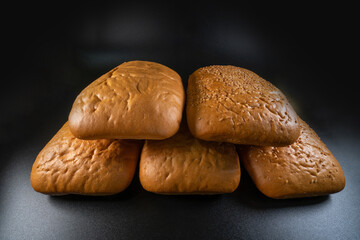 panini bun, sandwich. Without ingredients, on a black background. Bakery production concept.