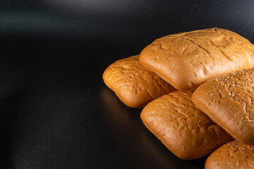 Lot of Panini bun with sesame, sandwich. Without ingredients, on a black background. Bakery production concept. Copy space