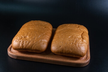 panini bun, sandwich. Without ingredients, on a black background. Bakery production concept.