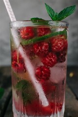 Summer mojito cocktail with raspberries, mint and lime on wooden background