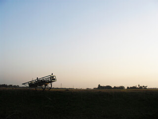 tractor in the field at sunset