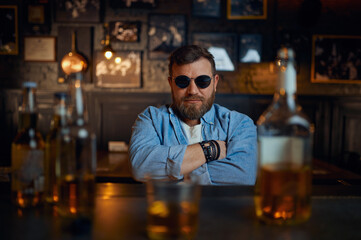 Man in sunglasses sitting at the counter in bar