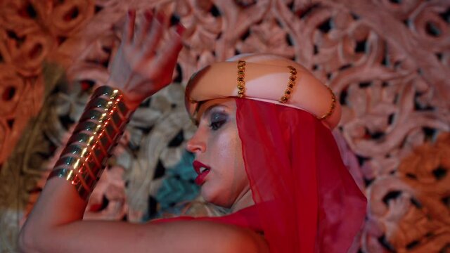 alluring blonde is wearing turkish or arabian gown and dancing sexually