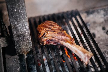 Juicy steak is grilled in a restaurant. Roasting meat in the fire on the grill.