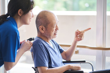 車椅子に乗る高齢者と介護士